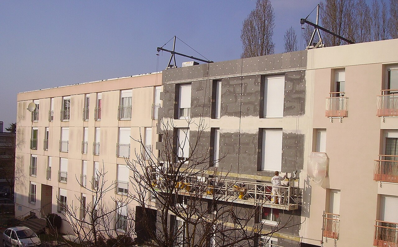 Façade d'immeuble en cours d'isolation par l'extérieur, panneaux et enduit